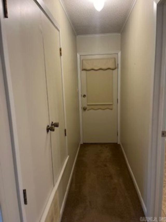 hall with ornamental molding, carpet, and a textured ceiling