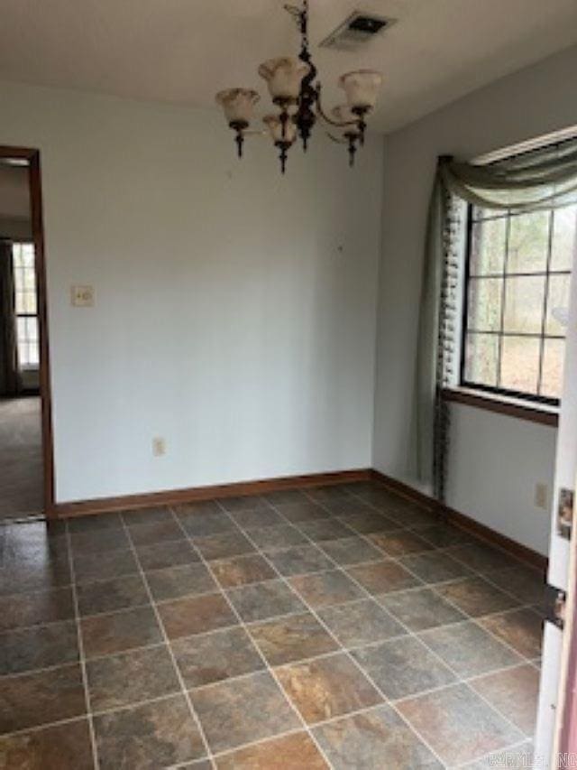 spare room with baseboards, visible vents, and a wealth of natural light