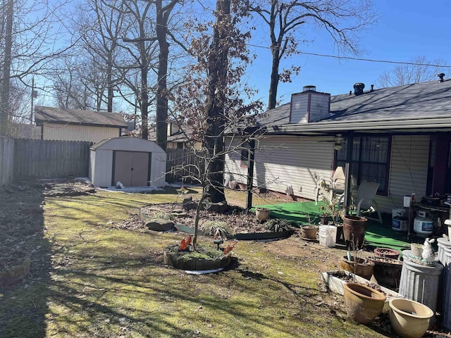 view of yard with a storage shed, an outbuilding, and a fenced backyard