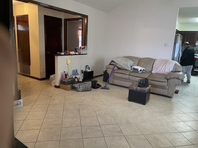 living area featuring baseboards and light tile patterned flooring