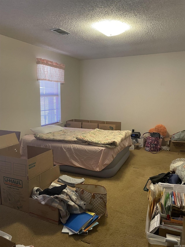 carpeted bedroom featuring visible vents and a textured ceiling