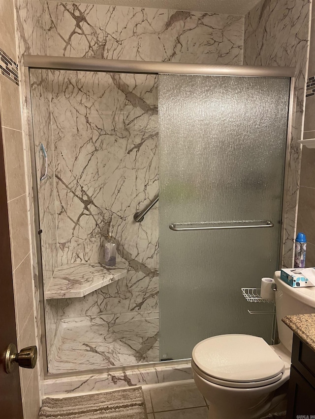 bathroom with vanity, a shower stall, and toilet