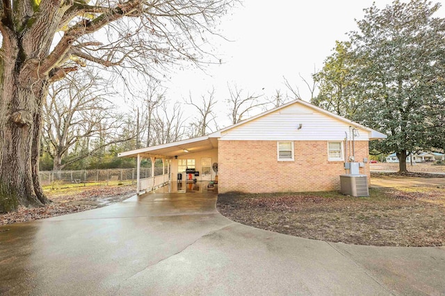 420 Sales St, Camden, AR 71701 - view of side of property with driveway, an attached carport, fence, central AC, and brick siding