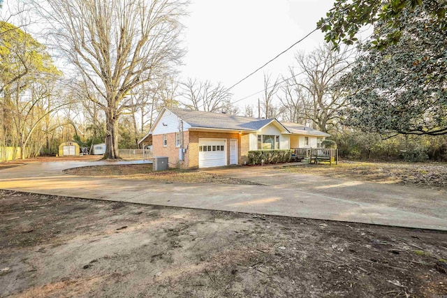 420 Sales St, Camden, AR 71701 - view of front of home featuring brick siding, an attached garage, a storage shed, an outdoor structure, and driveway