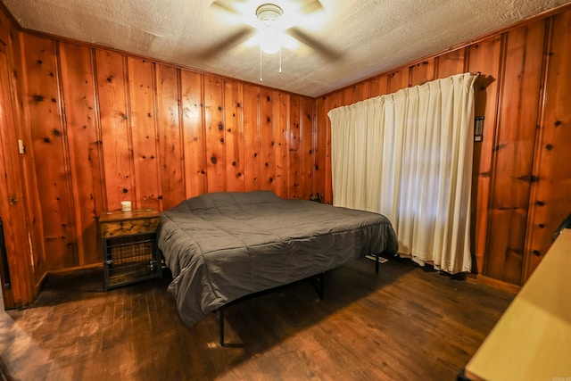 420 Sales St, Camden, AR 71701 - bedroom with dark wood finished floors, wood walls, and a textured ceiling
