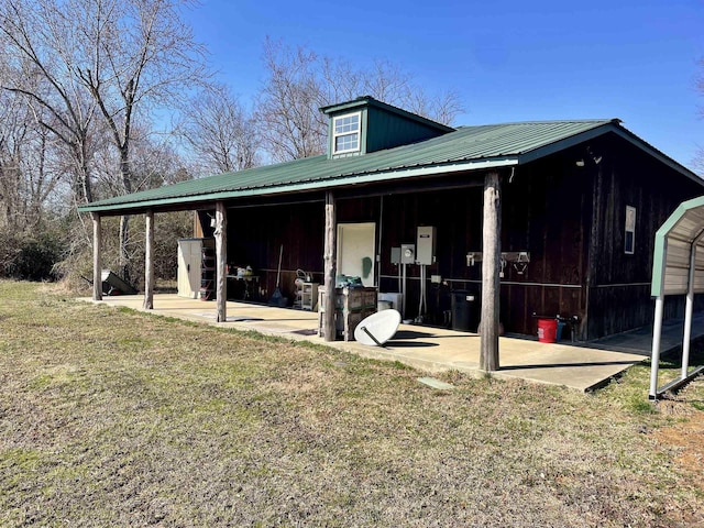 exterior space featuring metal roof and a lawn