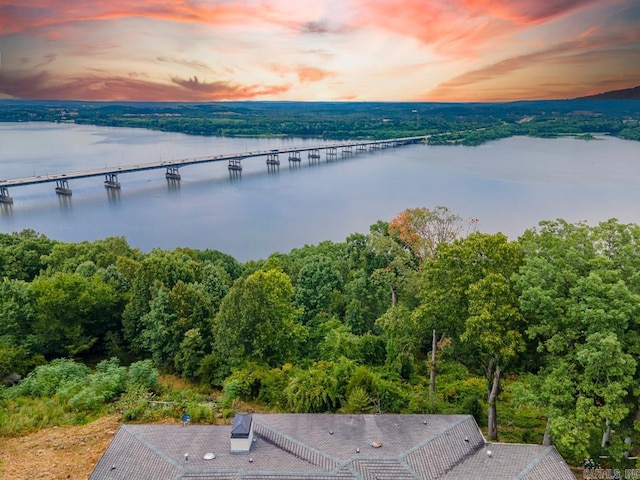 aerial view at dusk featuring a water view