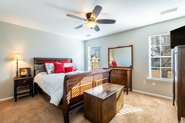 bedroom featuring visible vents, light carpet, and baseboards