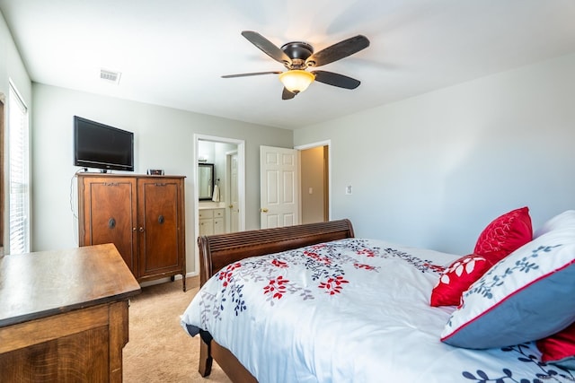 bedroom featuring ceiling fan, ensuite bath, visible vents, and light colored carpet