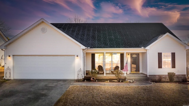 single story home featuring aphalt driveway, a yard, a shingled roof, covered porch, and a garage