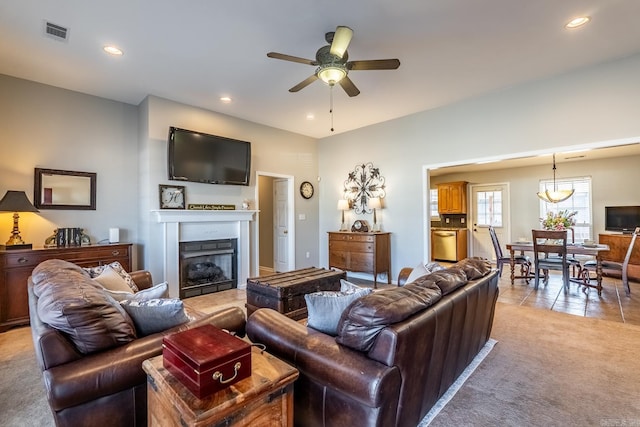 living room featuring recessed lighting, a fireplace, visible vents, and light colored carpet