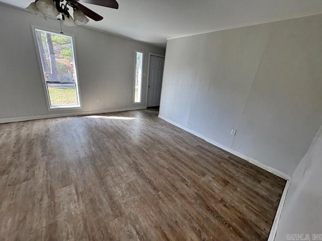 unfurnished room featuring wood finished floors, a ceiling fan, and baseboards