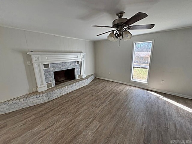 unfurnished living room with dark wood-type flooring, a fireplace, baseboards, and a ceiling fan