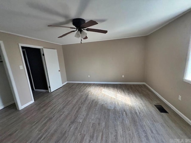 unfurnished bedroom featuring dark wood-type flooring, visible vents, baseboards, and a ceiling fan