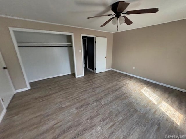 unfurnished bedroom featuring dark wood-style floors, baseboards, and crown molding