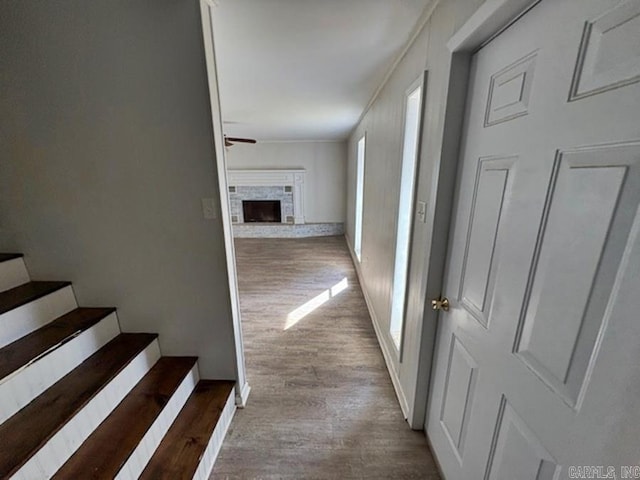 corridor with light wood finished floors, baseboards, and stairway