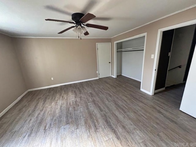 unfurnished bedroom with baseboards, ornamental molding, dark wood finished floors, and a ceiling fan