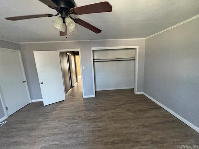 unfurnished bedroom with baseboards, a ceiling fan, dark wood-style flooring, crown molding, and a closet