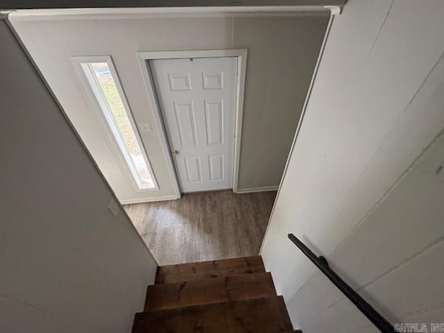 stairway with wood finished floors and a wealth of natural light