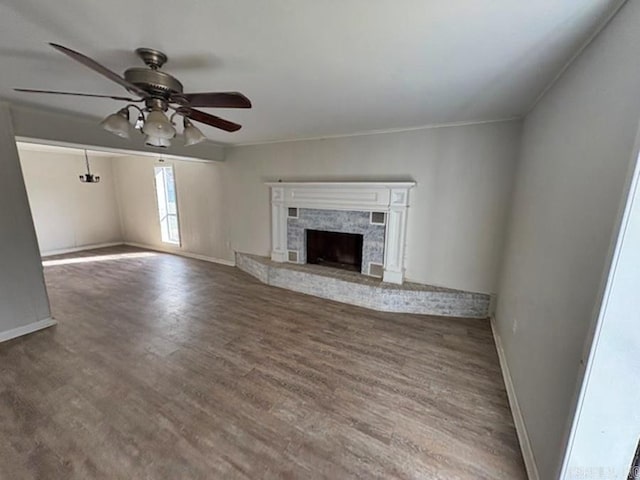 unfurnished living room featuring a ceiling fan, wood finished floors, baseboards, and a premium fireplace