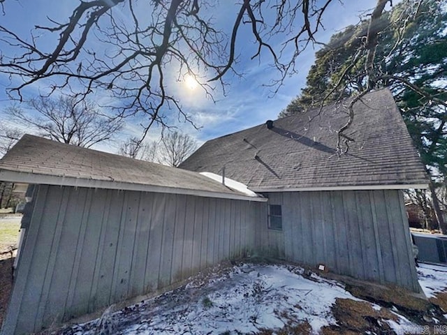 view of snow covered exterior with a shingled roof