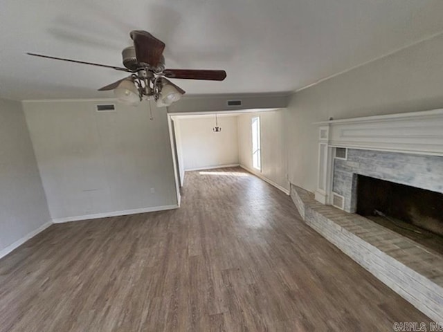 unfurnished living room featuring visible vents, a fireplace, baseboards, and wood finished floors