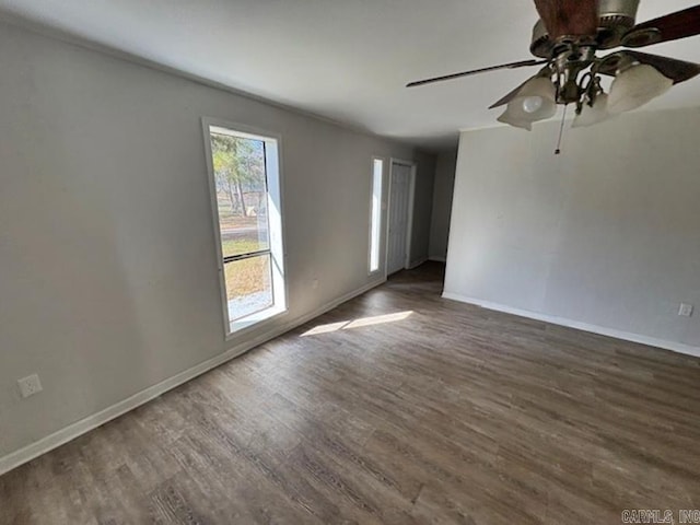 empty room featuring ceiling fan, dark wood-type flooring, and baseboards