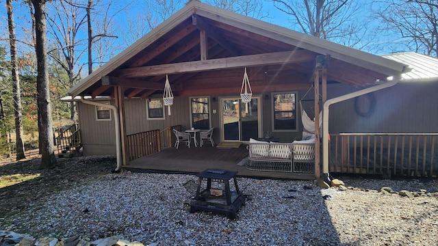 back of property featuring a deck and a fire pit