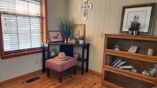 sitting room with light wood-style flooring, visible vents, and baseboards