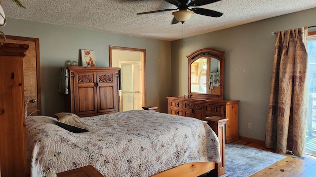 bedroom with light wood finished floors, multiple windows, baseboards, and a textured ceiling