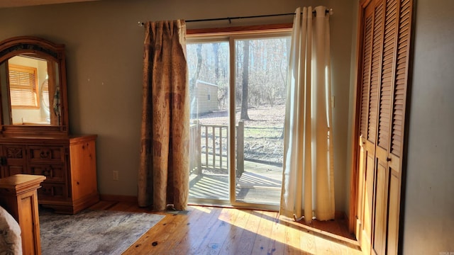 unfurnished bedroom with access to exterior and light wood-style flooring