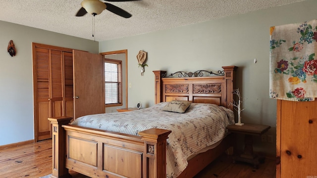 bedroom featuring a textured ceiling, a closet, wood finished floors, and a ceiling fan