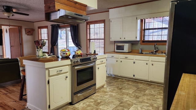 kitchen featuring a textured ceiling, under cabinet range hood, stainless steel appliances, a sink, and ornamental molding