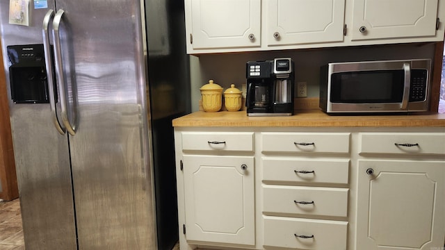 kitchen with stainless steel appliances, light countertops, and white cabinets