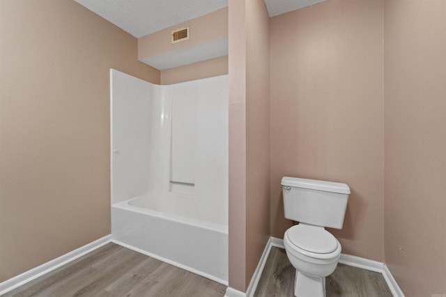 bathroom featuring baseboards, visible vents, toilet, and wood finished floors