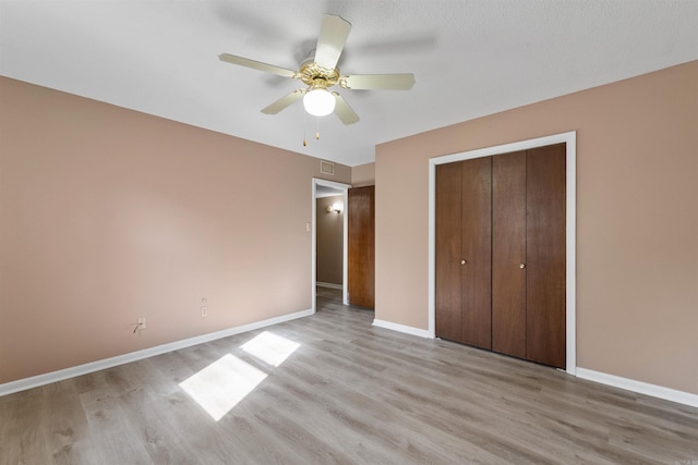 unfurnished bedroom featuring a closet, light wood-type flooring, visible vents, and baseboards