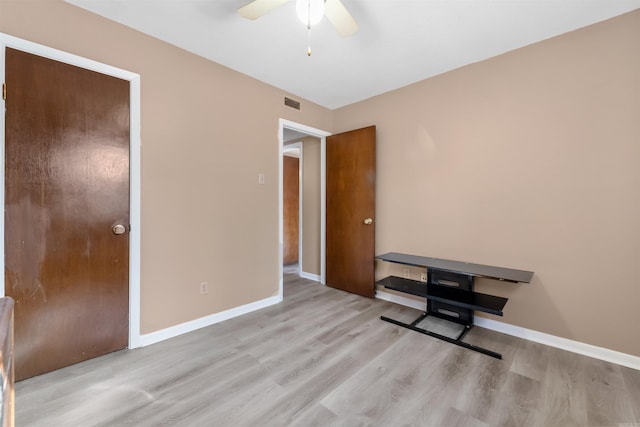 bedroom with light wood-style floors, visible vents, ceiling fan, and baseboards