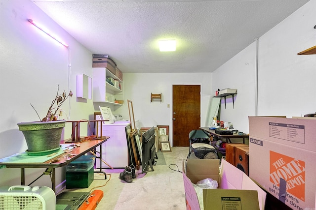 interior space featuring washer / clothes dryer, unfinished concrete flooring, and a textured ceiling