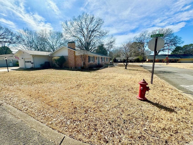 view of property exterior featuring a garage and a chimney