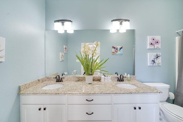 bathroom featuring a sink, toilet, and double vanity