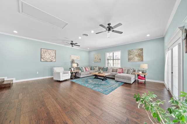 living area featuring attic access, dark wood-style flooring, crown molding, and baseboards