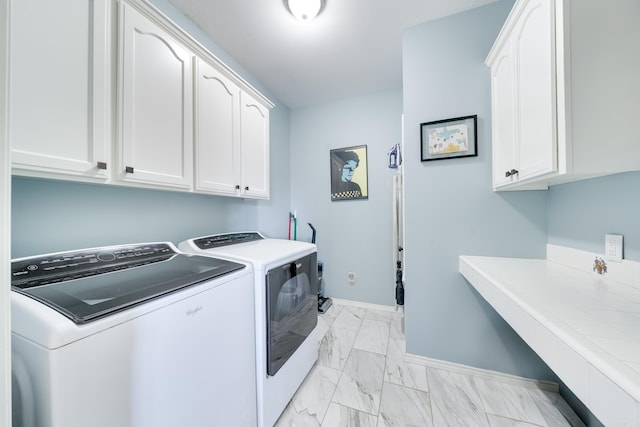 laundry room with cabinet space, baseboards, marble finish floor, and washer and clothes dryer