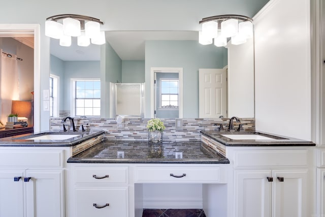 bathroom with a stall shower, decorative backsplash, a notable chandelier, and vanity