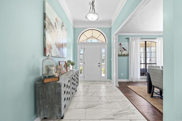 foyer featuring marble finish floor, crown molding, and baseboards