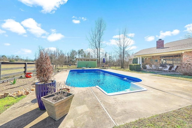 outdoor pool with a patio area and fence private yard