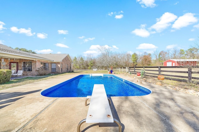 view of swimming pool with a diving board, a patio area, a fenced backyard, and a fenced in pool