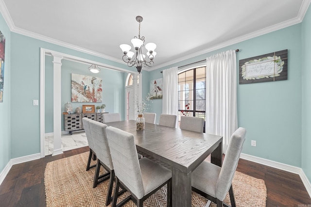 dining space featuring crown molding, baseboards, a chandelier, and wood finished floors