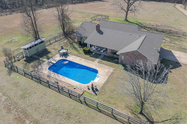 view of pool featuring a fenced in pool, a patio, a fenced backyard, a rural view, and an outdoor structure