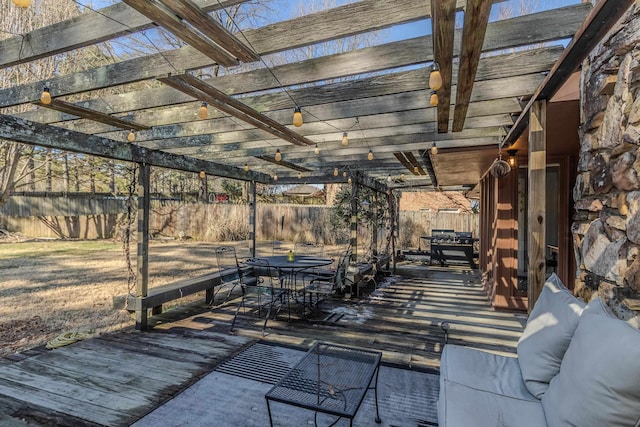 view of patio featuring outdoor dining space, fence, a wooden deck, and a pergola