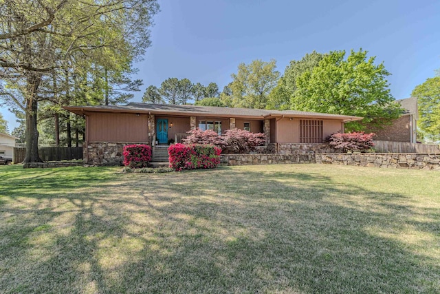 exterior space with stone siding, fence, and a lawn